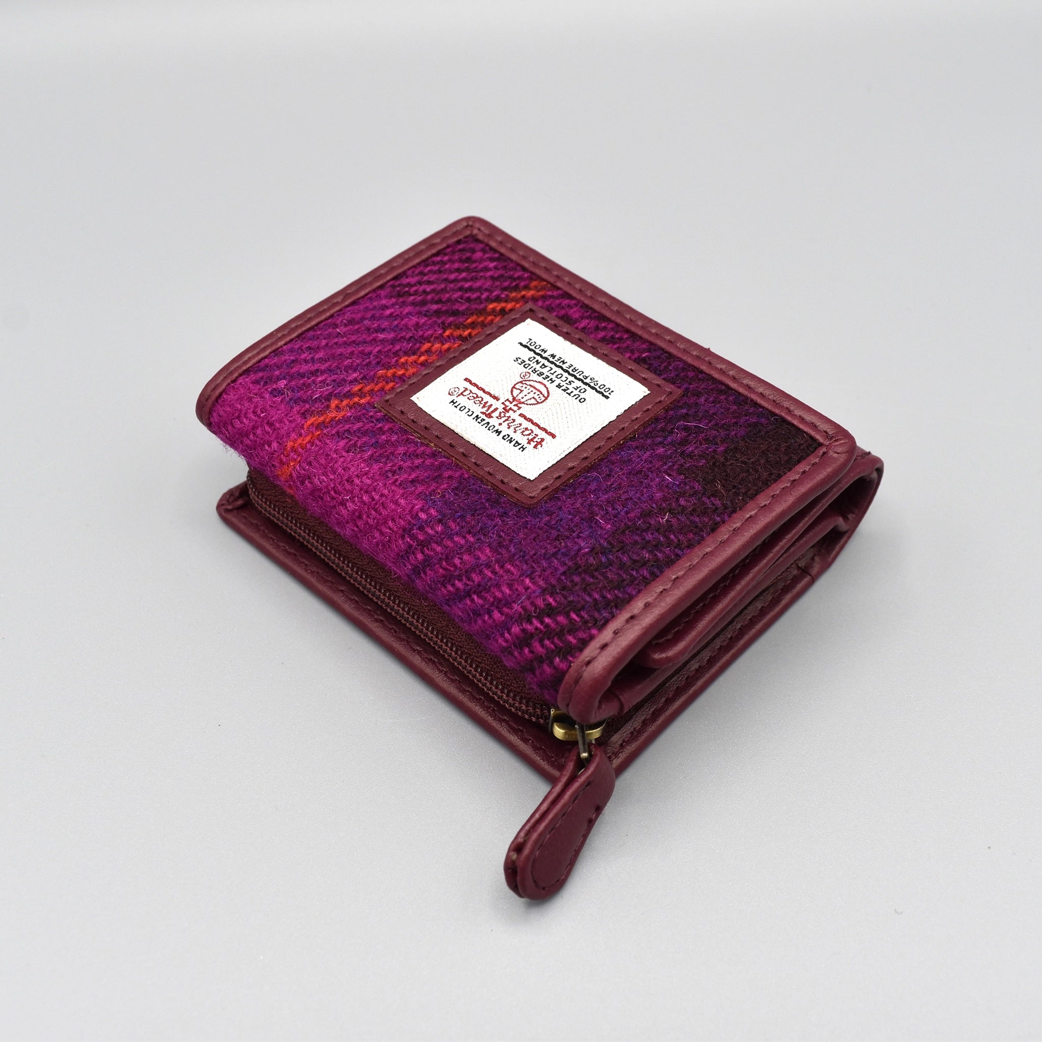 A purple faux leather purse with genuine check Harris Tweed in the front with zip