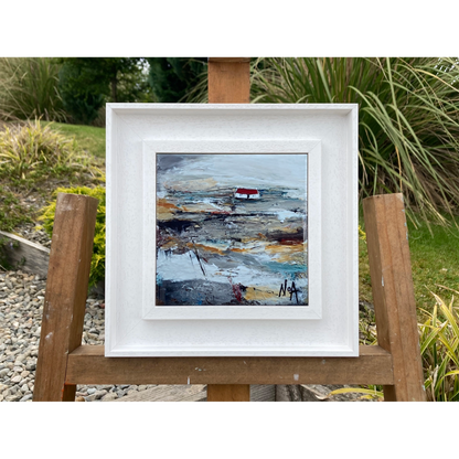 A ceramic tile printed with an abstract painting of a cottage mounted on a white frame