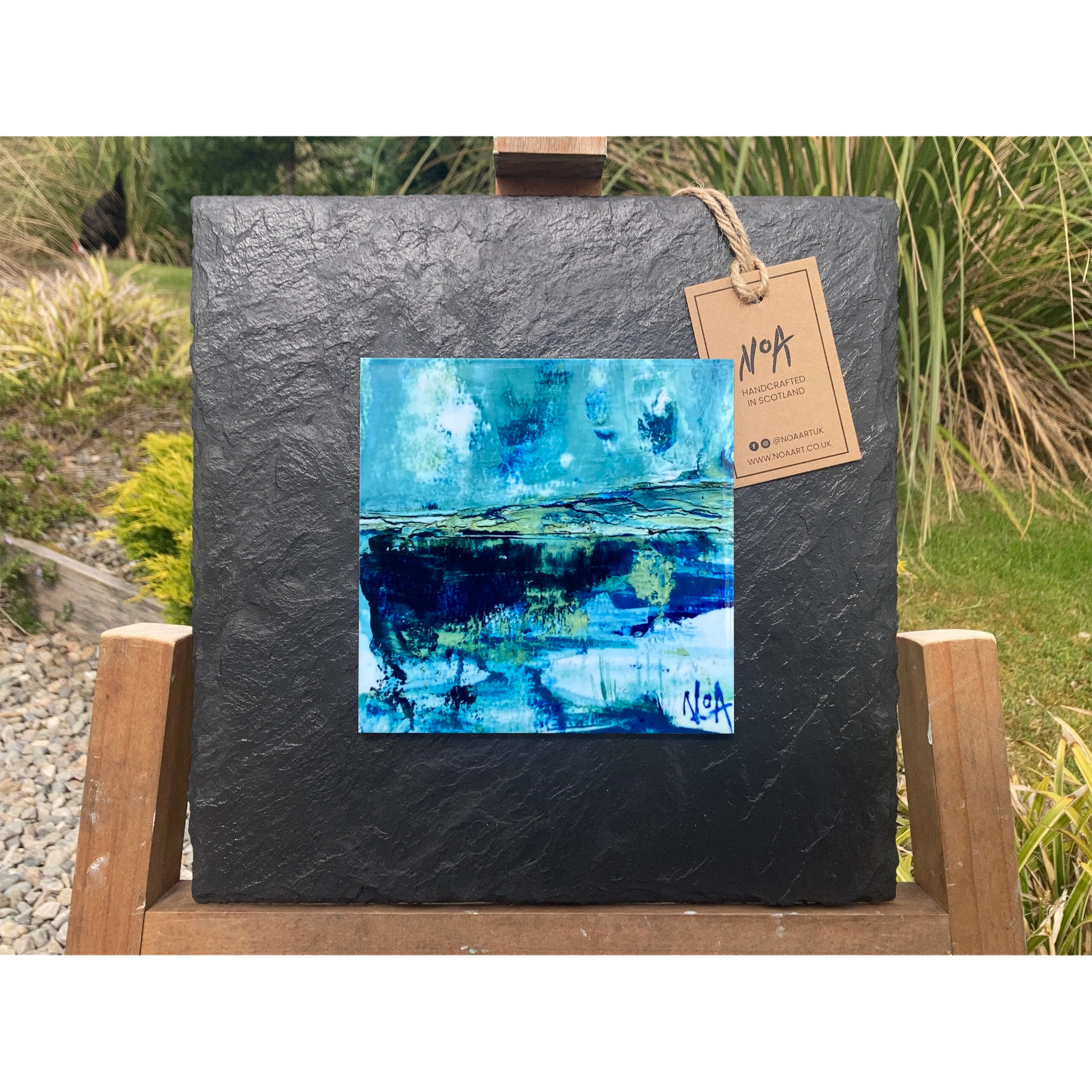 A tile mounted on slate featuring a textured painting of a water reflection on the West Coast of Scotland