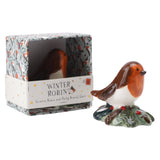 A glossy ceramic ornament of a little robin sitting on a holly bush with packaging