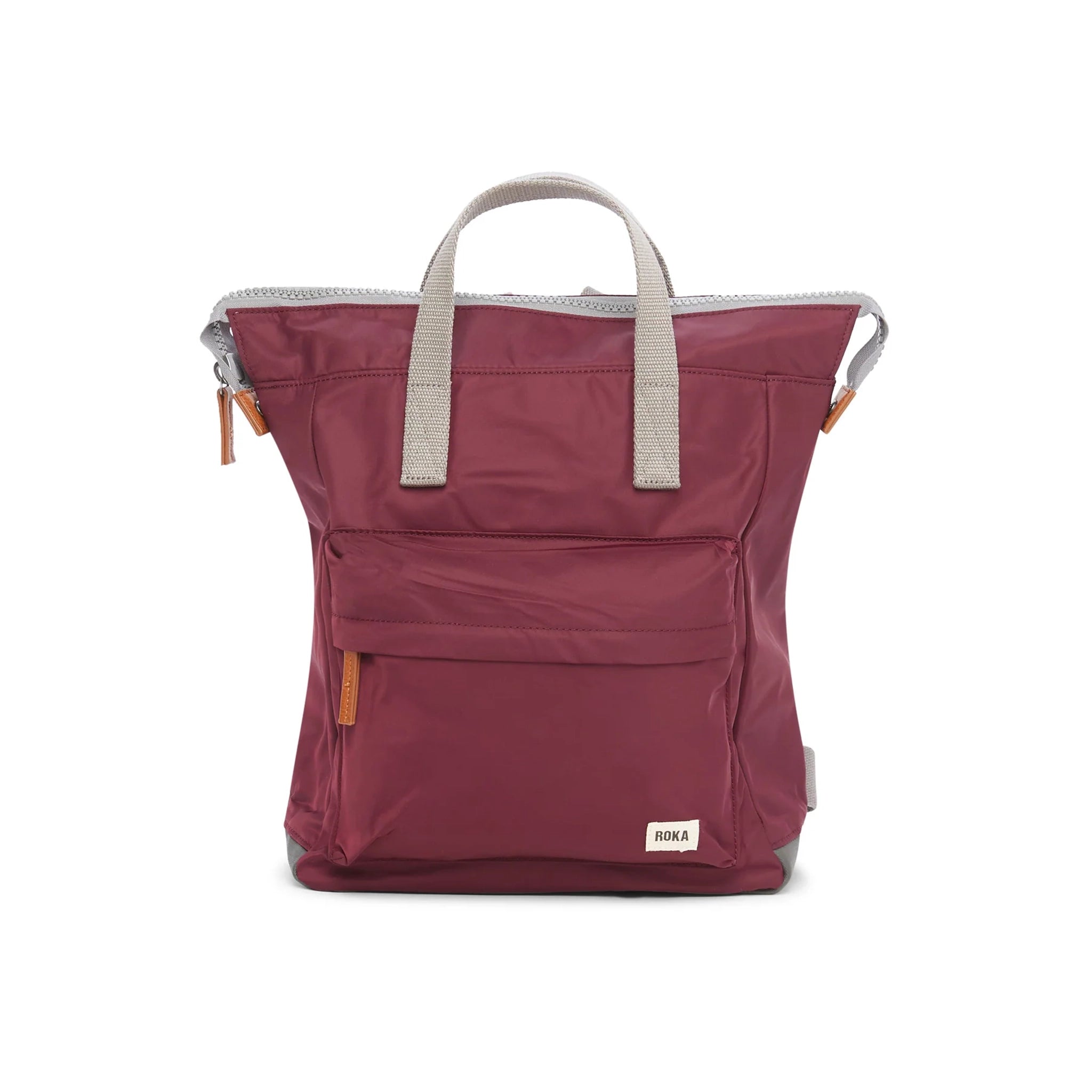 A nylon backpack in a plum red colour with grey handles and front zip pocket