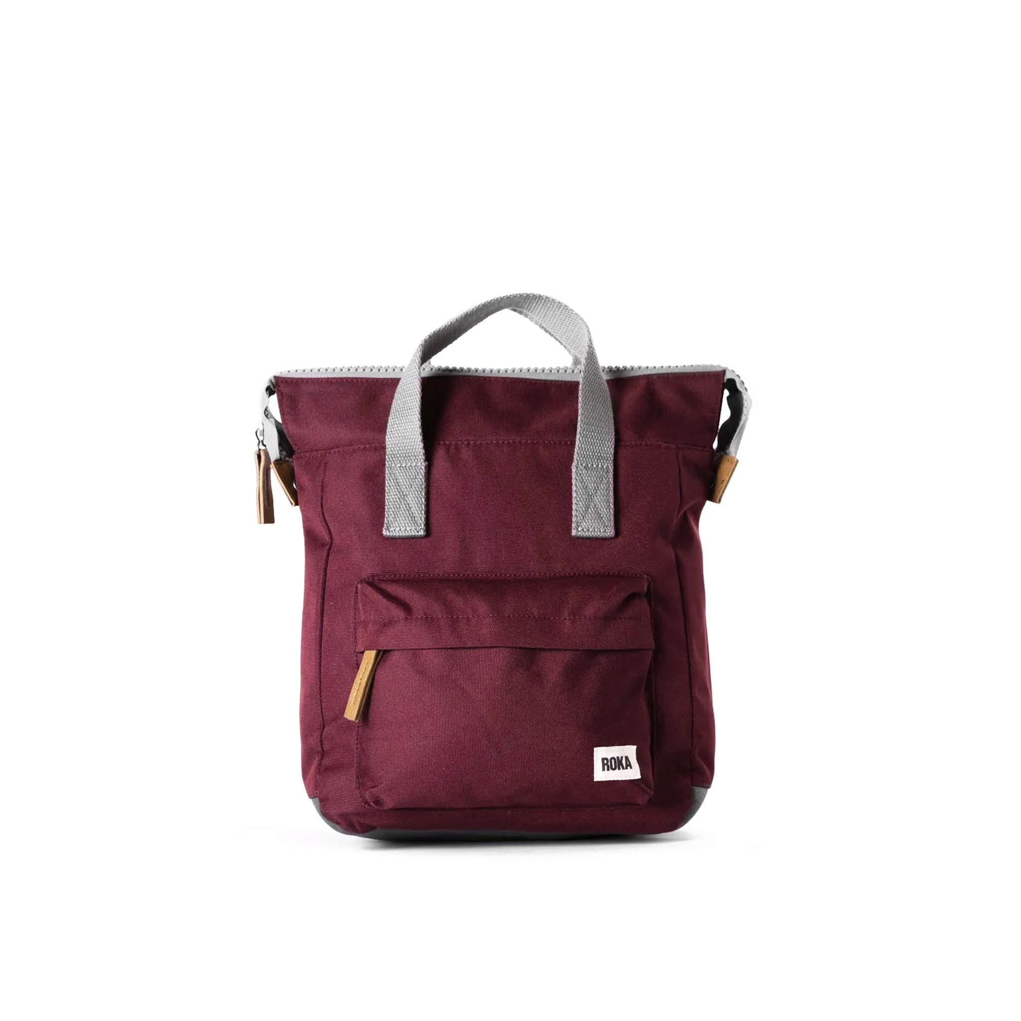 A canvas backpack in a red sienna colour with grey handles and front zip pocket