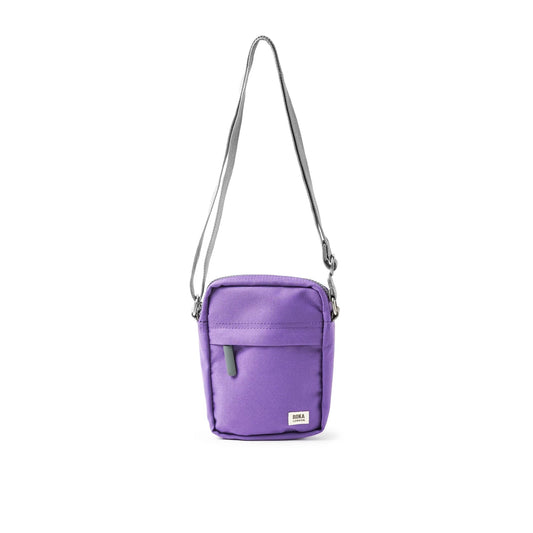 A small crossbody bag in canvas material and a bright purple colour