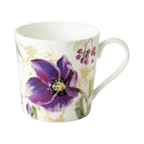 A white mug with a print of purple hellebore flowers, red berries and gold accents