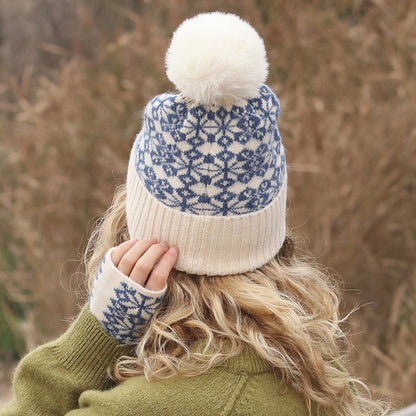 Mode wearing a Scandi style star patterned faux fur pompom hat in blue and cream back view