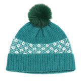 A green knitted pompom hat with a Scandi style white floral band design