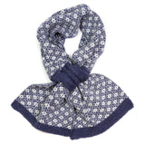 A knitted pull-through scarf with a navy and white Scandi style floral design