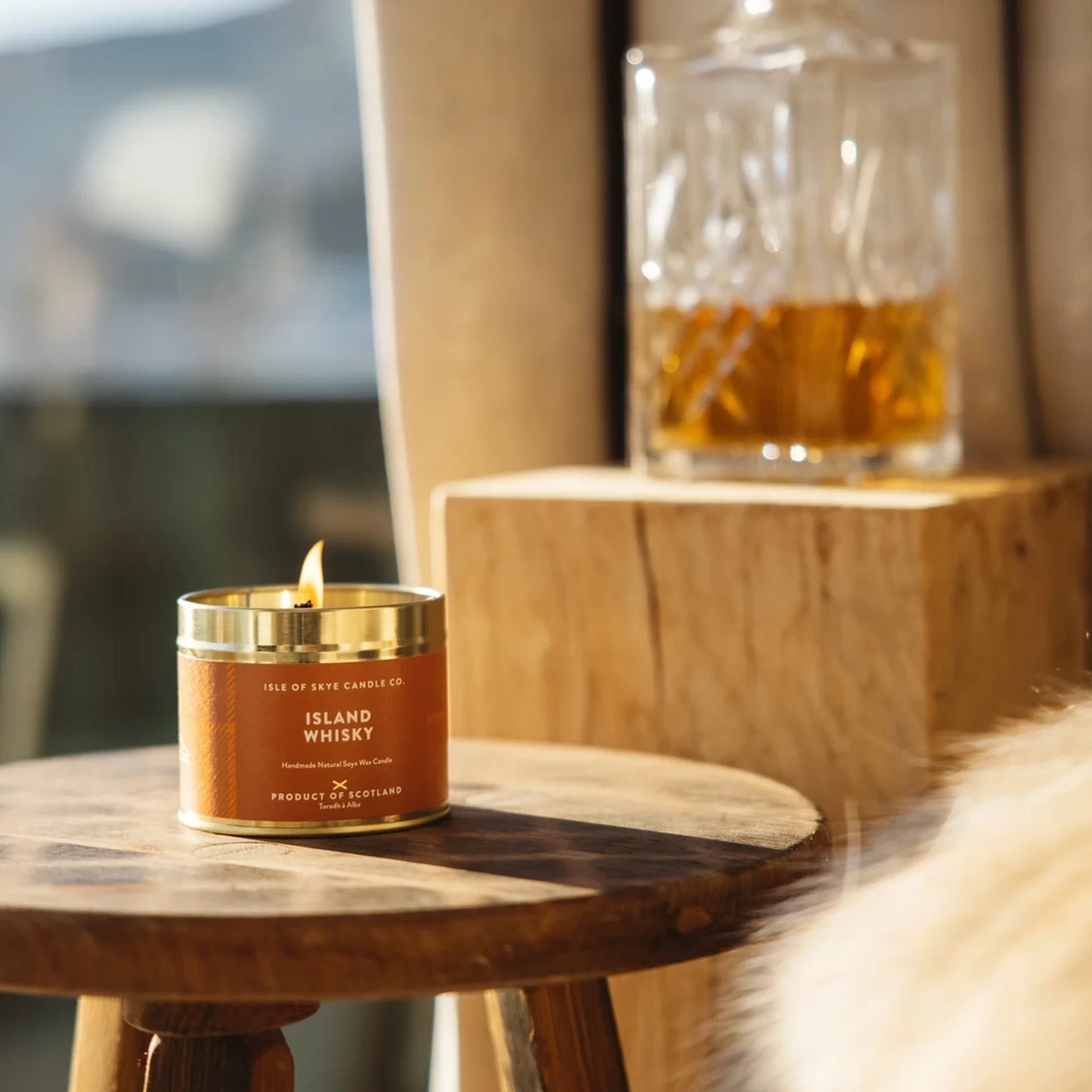 Gold toned travel tin candle with orange tartan design in the scent Island whisky lifestyle