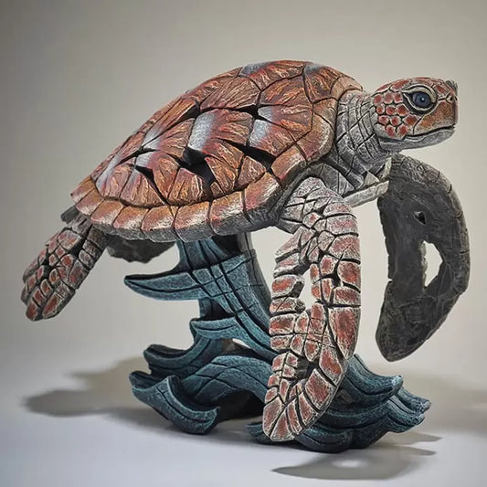 A textured and painted sea turtle surfing waves sculpture