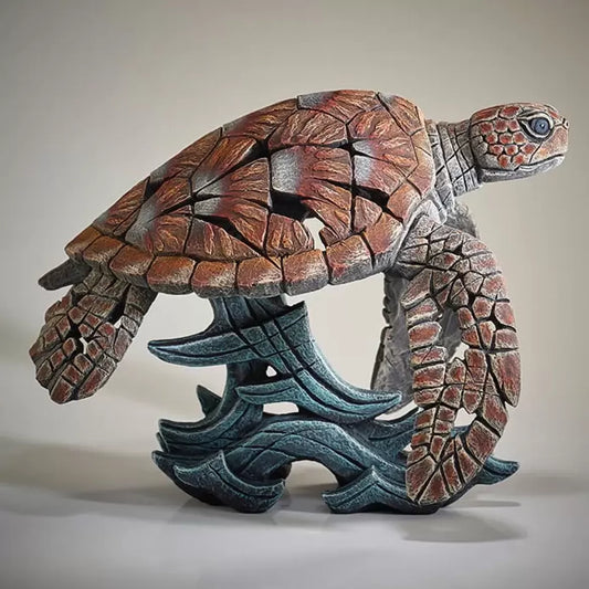 A textured and painted sea turtle surfing waves sculpture from side