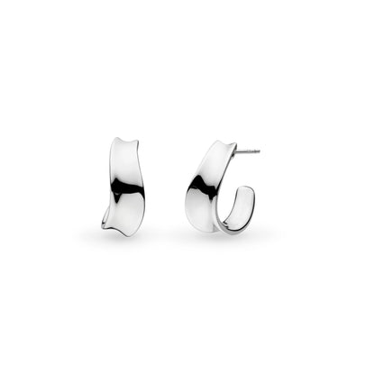 A pair of silver huggie hoop earrings with a ribbon like shape