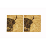 Two square wooden coasters with an engraved Highland cow on each