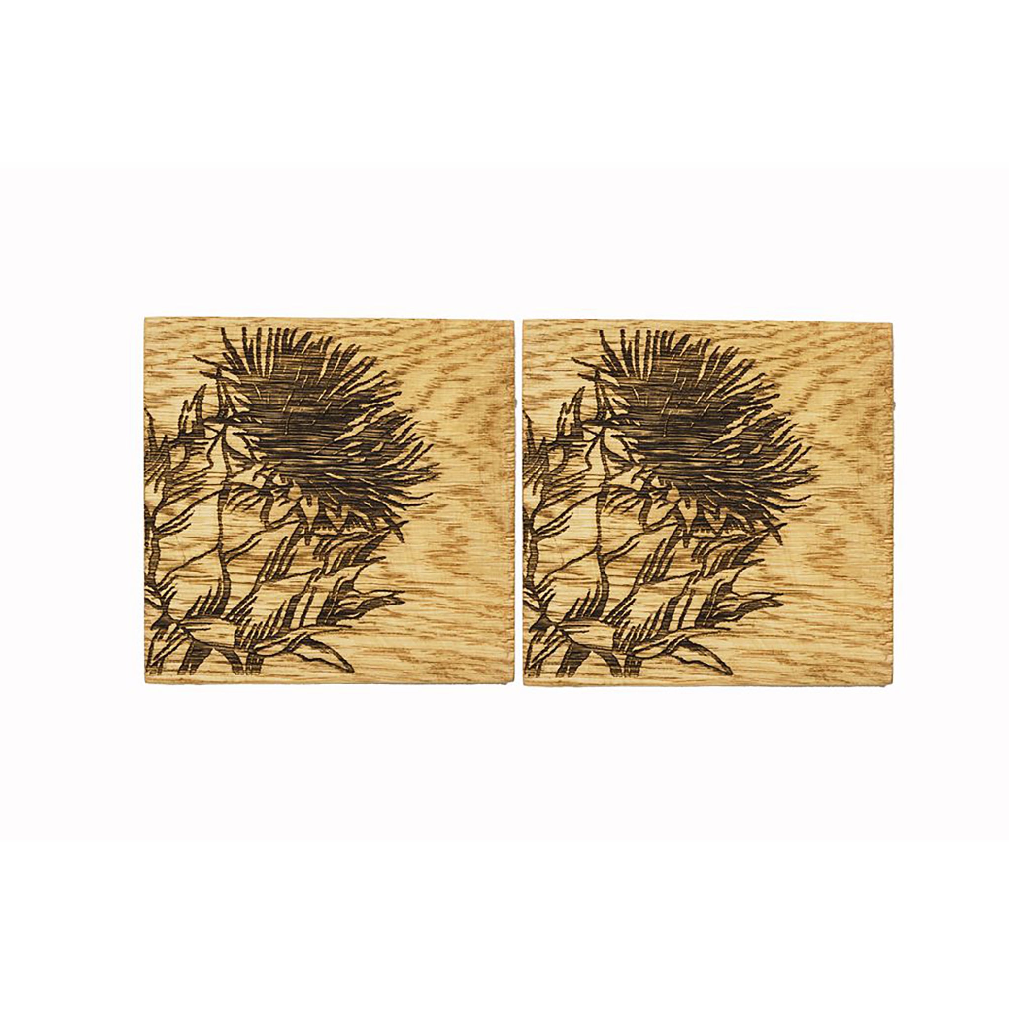Two square wooden coasters with an engraved Scottish thistle on each