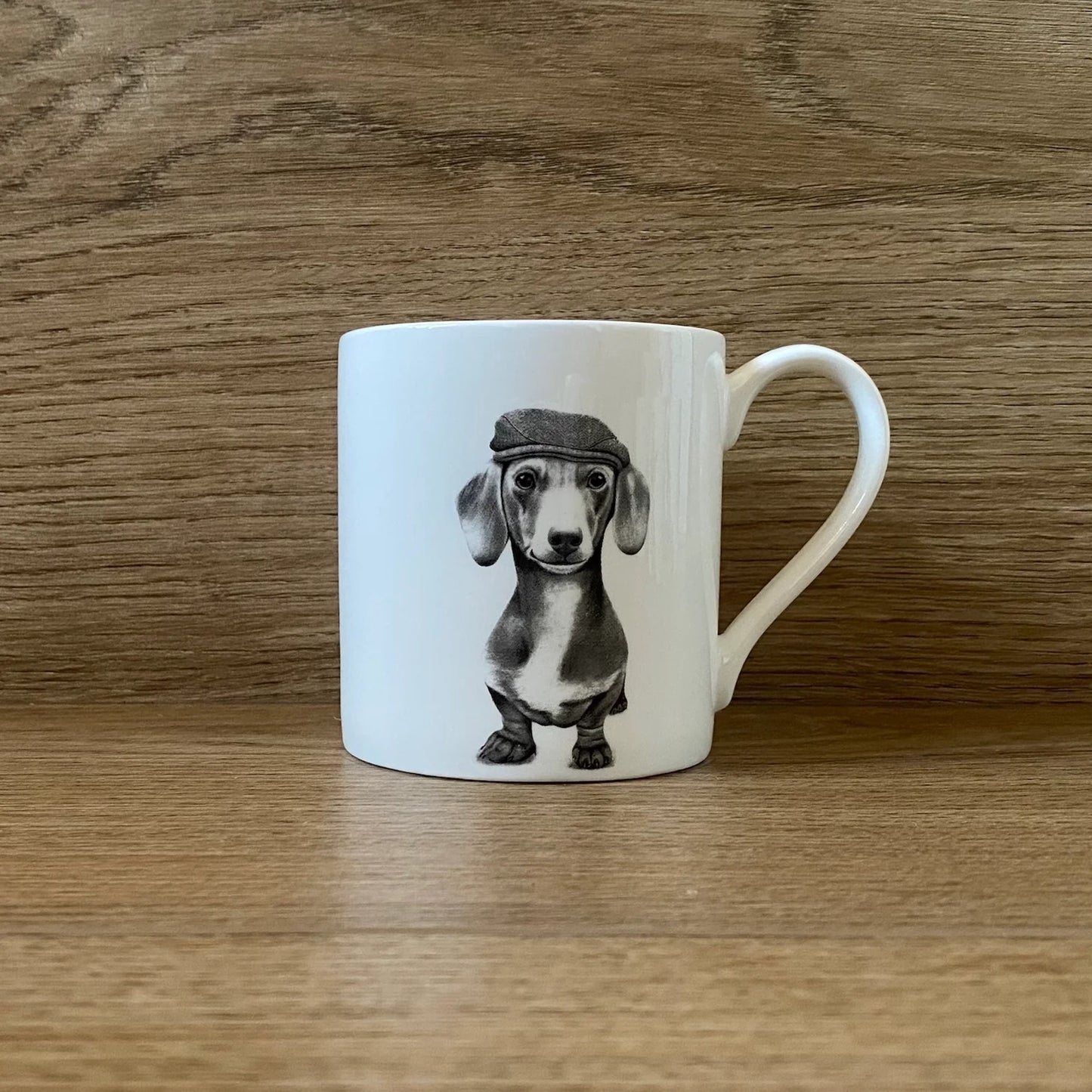 White mug with grey illustration of a sausage dog in a beret hat