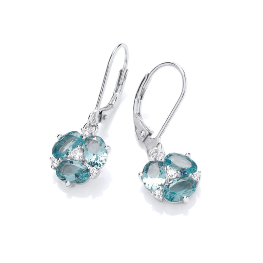A pair of earrings with oval cut blue CZ stones in the shape of lily flowers