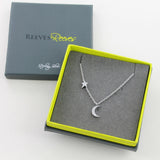 A silver necklace featuring a moon and star set with cubic zirconia stones in packaging