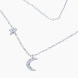 A silver necklace featuring a moon and star set with cubic zirconia stones