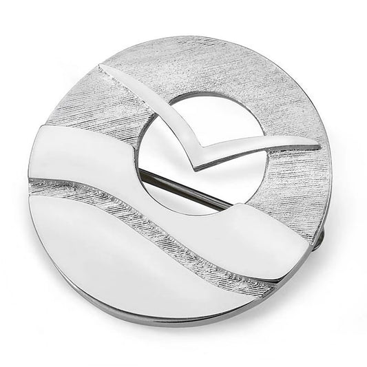 A round silver brooch featuring a flying seabird in front of a cut out sun over abstract waves