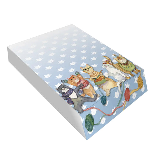 A slanted pad block featuring an illustration of little cats in winter clothing and knitting