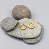 A pair of hammered textured small huggie hoop earrings in gold