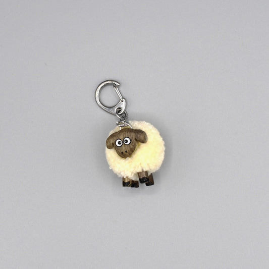 A white pompom sheep keyring with wooden face and legs