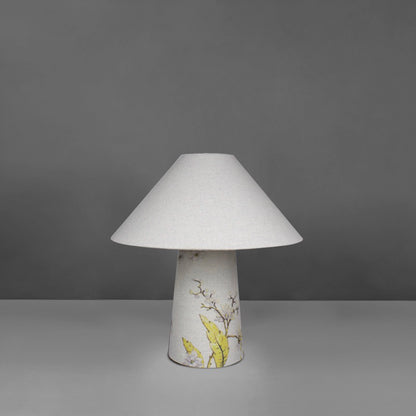 A small fabric table lamp with shade and a yellow blossom design on the conical base