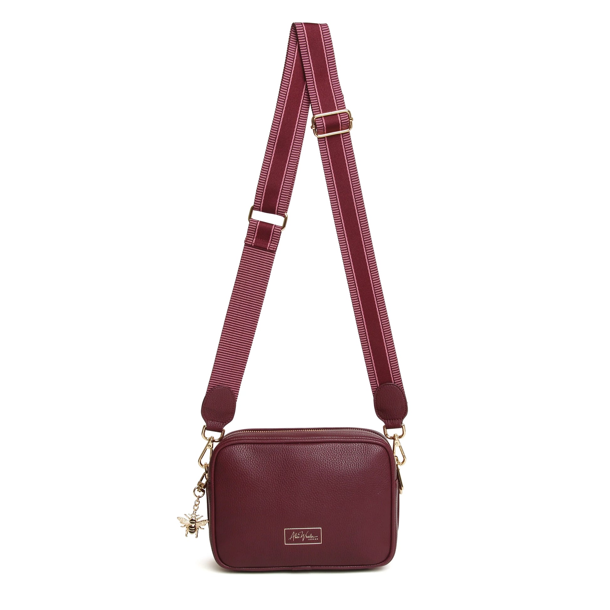 A berry red faux leather cross body bag with adjustable patterned canvas strap