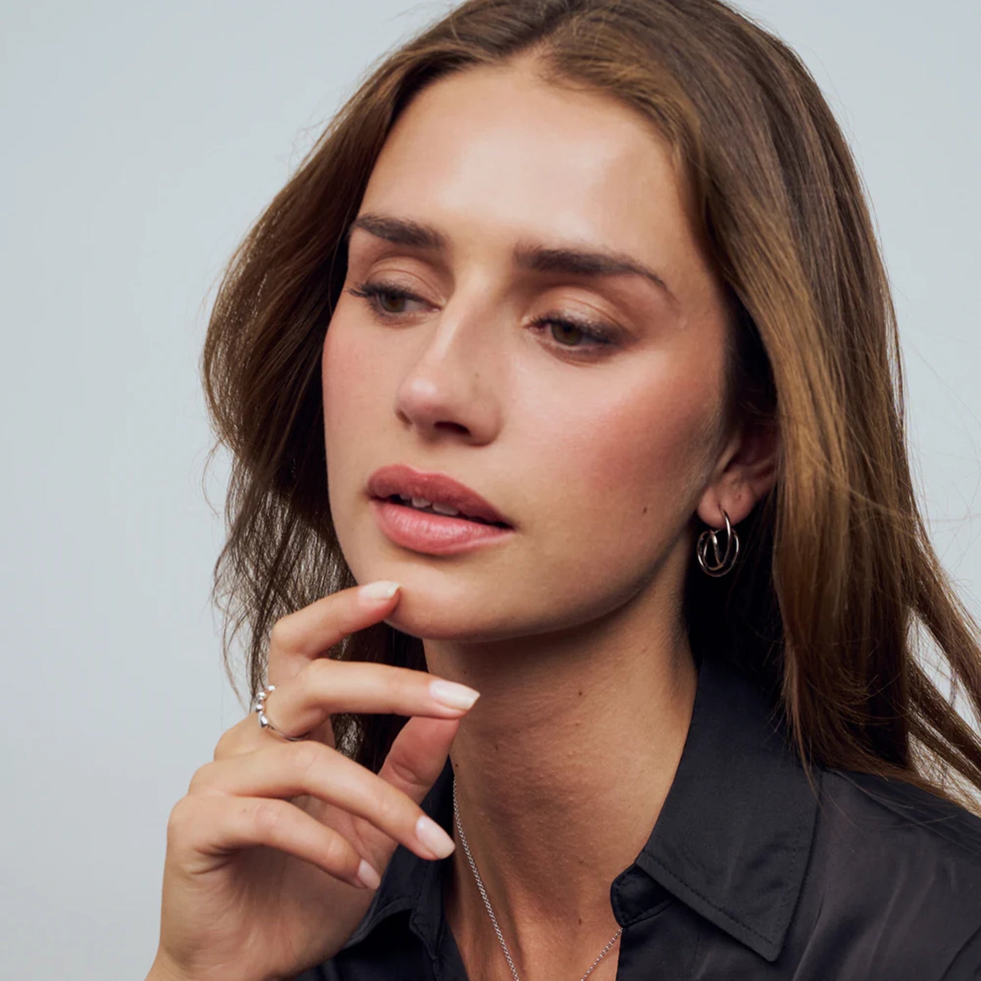 Model wearing intricate spiral shaped silver earrings 