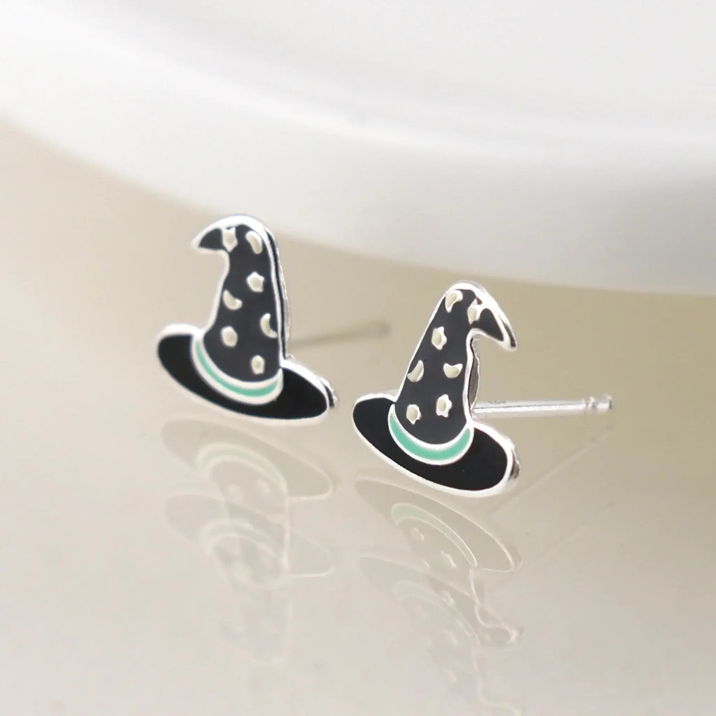 Pair of silver stud earrings shaped like witch hats with enamelled details