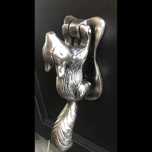 A silver gunmetal coloured metal squirrel door knocker