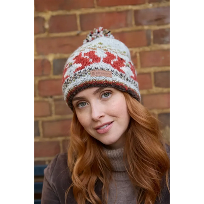 Model wearing a knitted beanie bobble hat with a squirrel fair isle pattern