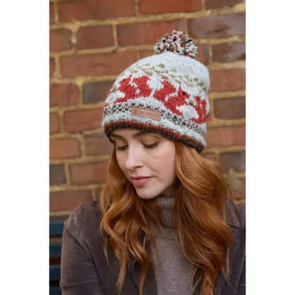 Model wearing a knitted beanie bobble hat with a squirrel fair isle pattern