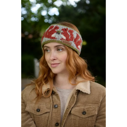 Model wearing knitted headband with row of red squirrels and acorn pattern