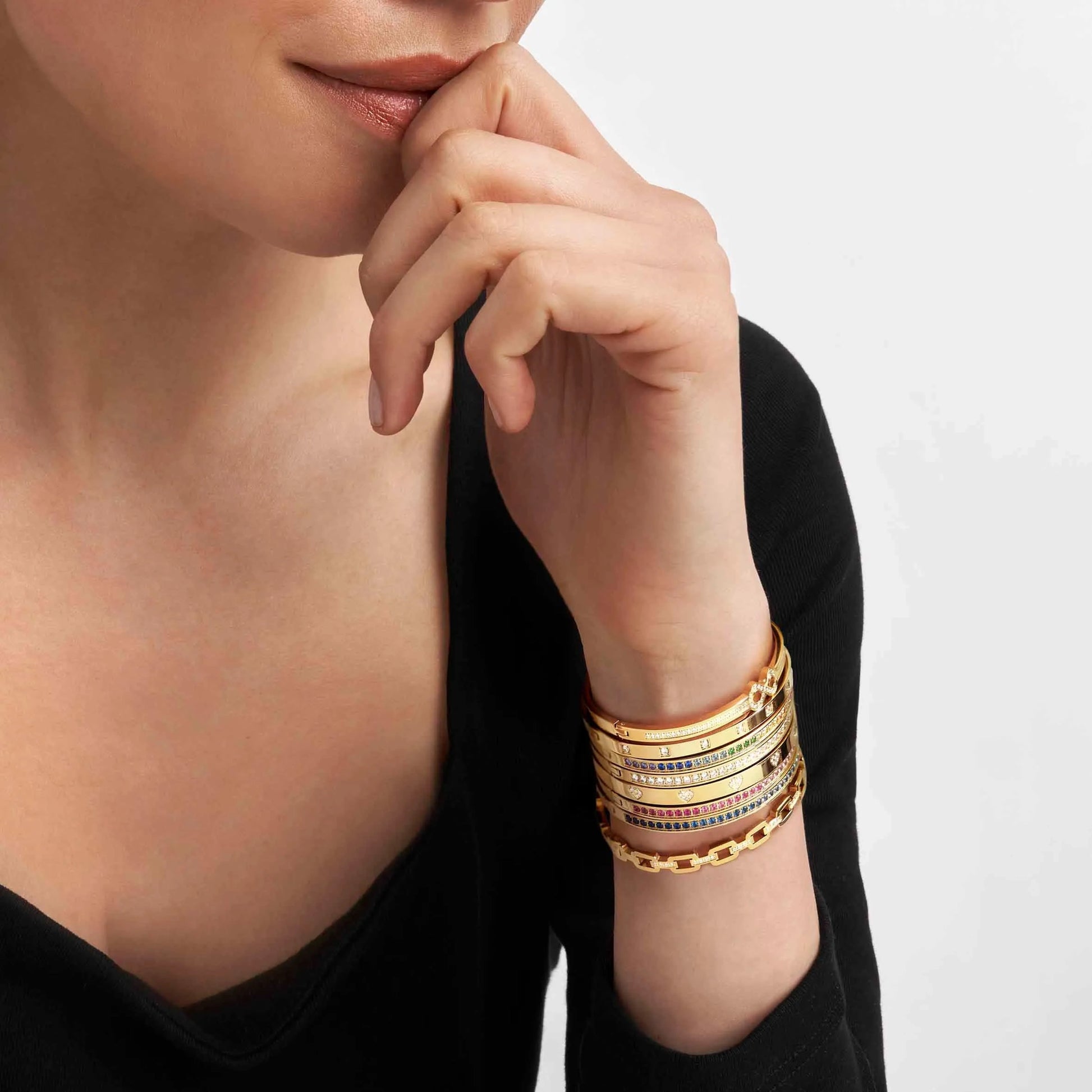 Model wearing stacked yellow gold Nomination bangles