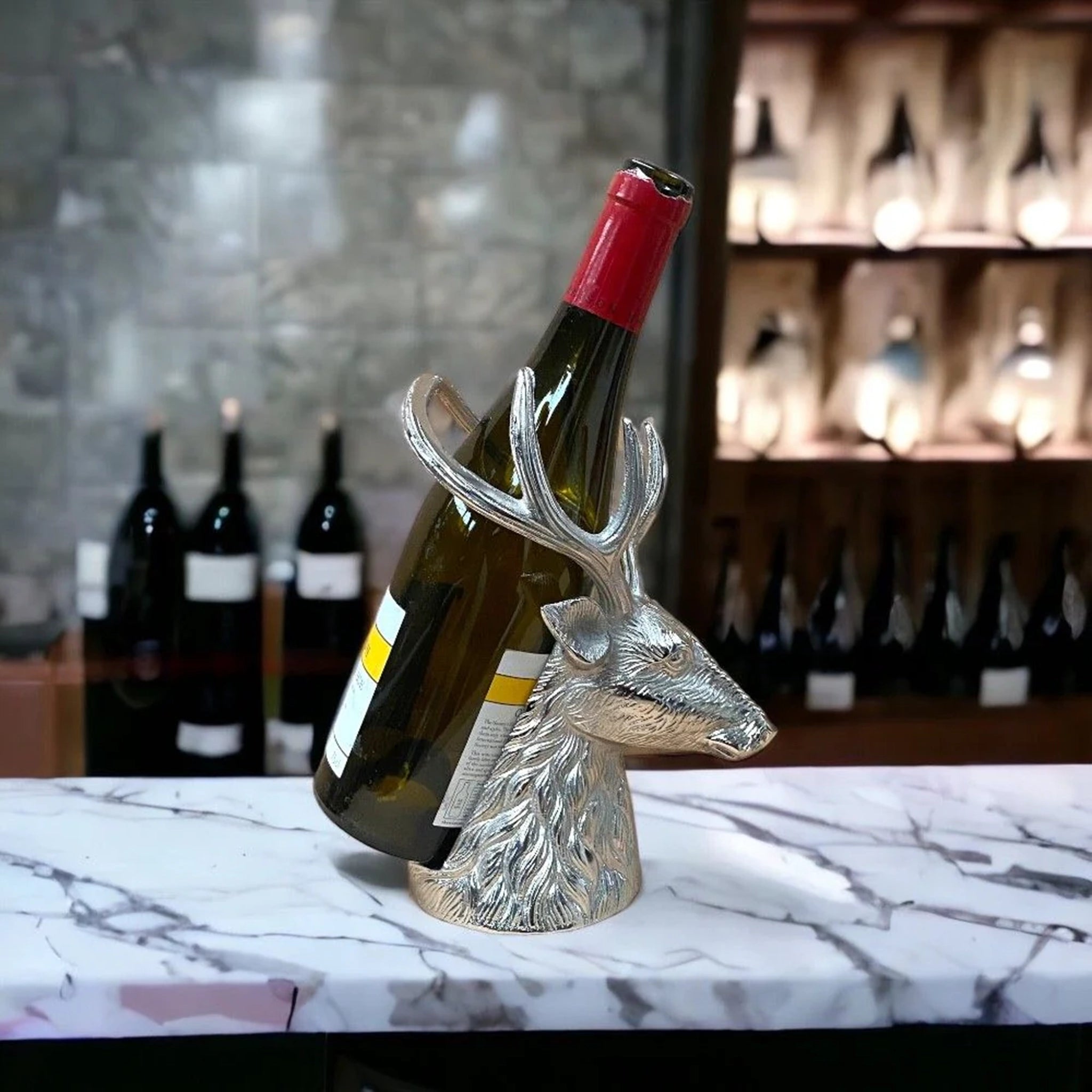 A stag head shaped bottle holder in shiny aluminium