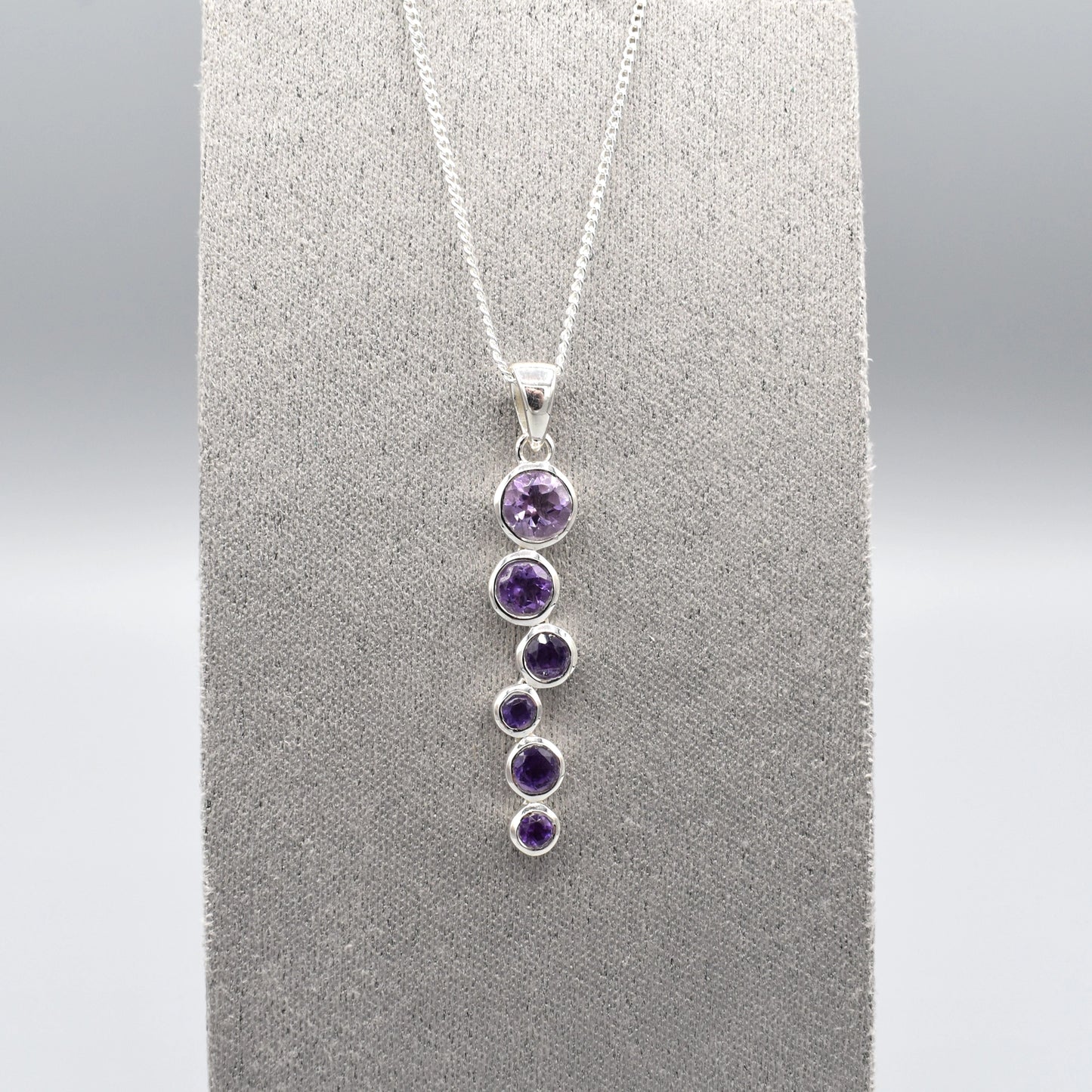 Silver pendant with cascading round amethyst stones and a silver chain