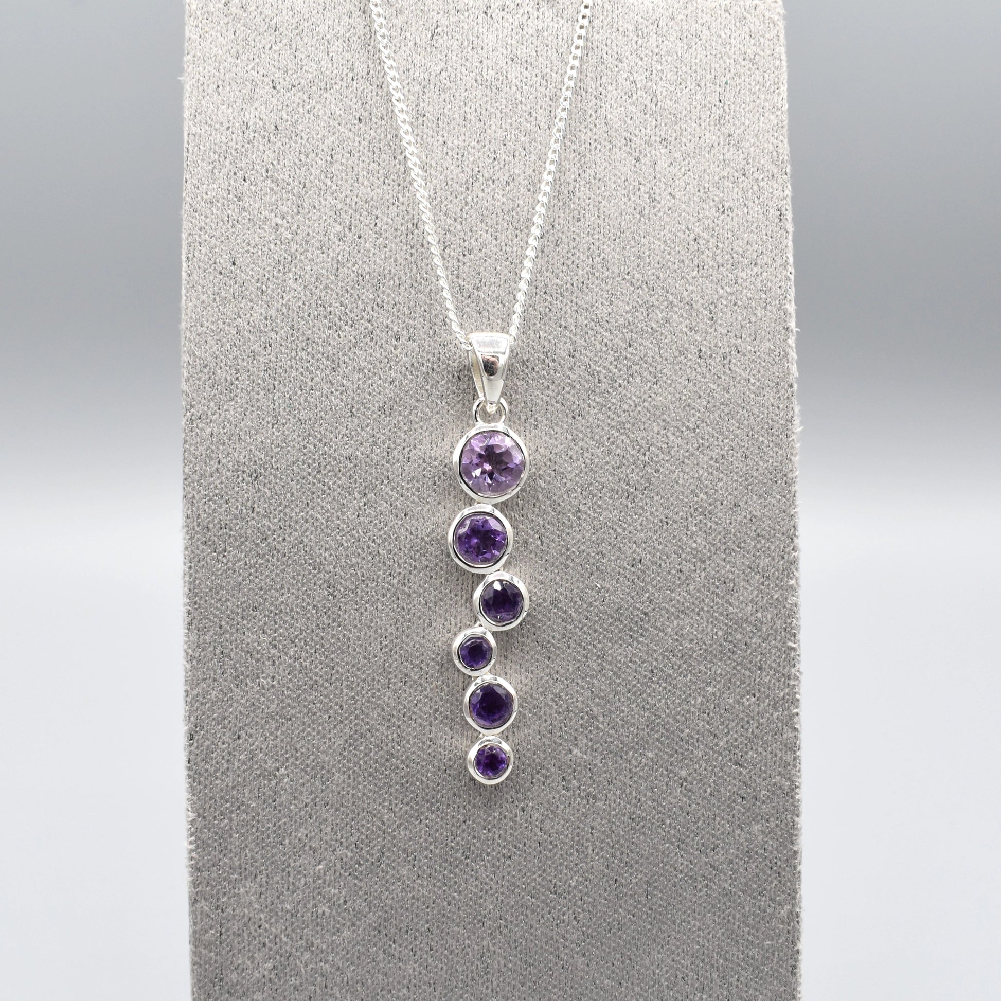 Silver pendant with cascading round amethyst stones and a silver chain