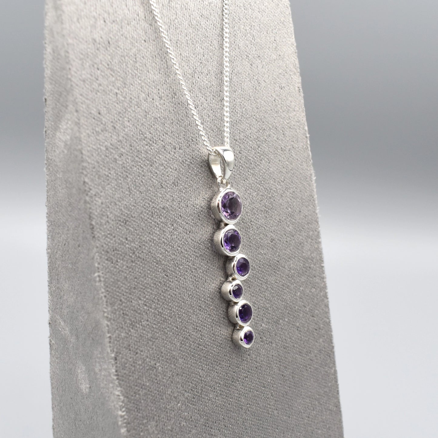 Silver pendant with cascading round amethyst stones and a silver chain