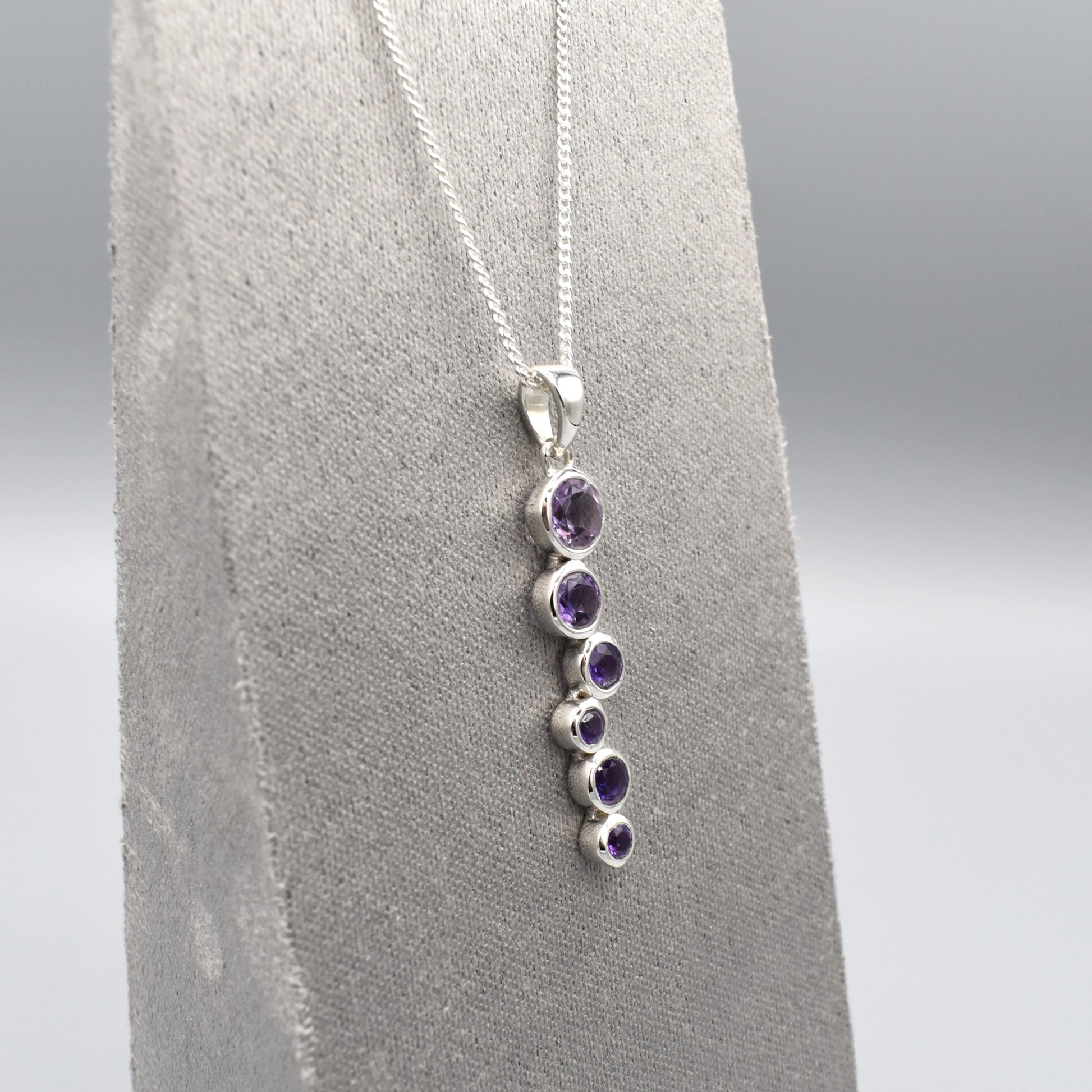Silver pendant with cascading round amethyst stones and a silver chain