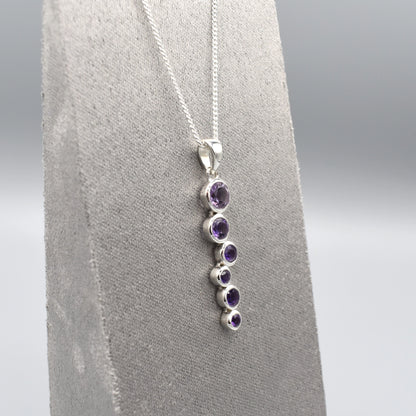 Silver pendant with cascading round amethyst stones and a silver chain