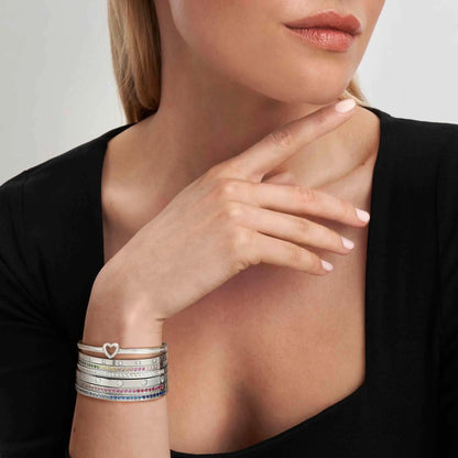 Model wearing stacked stainless steel Nomination bangles