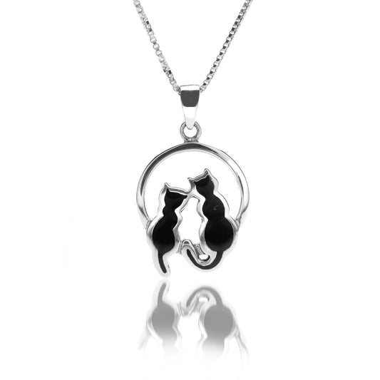 A silver pendant featuring a round frame with two sitting black cats