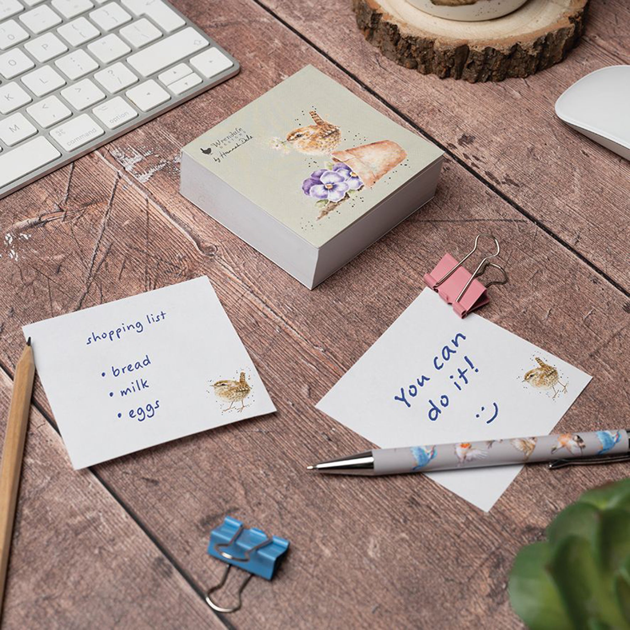 A notepad of sticky notes with an illustration of a wren in a toppled pot of purple pansies lifestyle