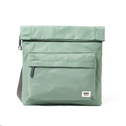 A square mint green nylon bag with grey cotton strap and roll top