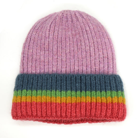 A knitted beanie hat in lilac with a ribbed rainbow striped turn up