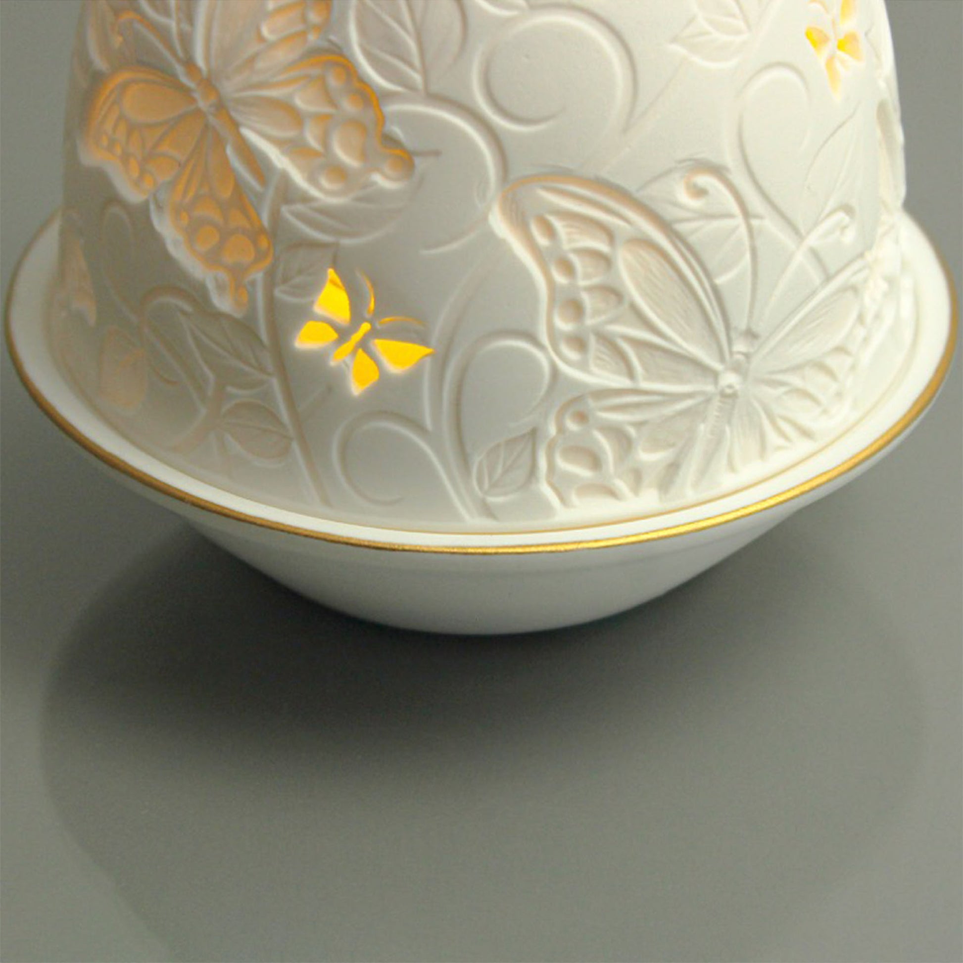 White porcelain tall dome candle holder with engraved butterflies and gold rimmed plate detail