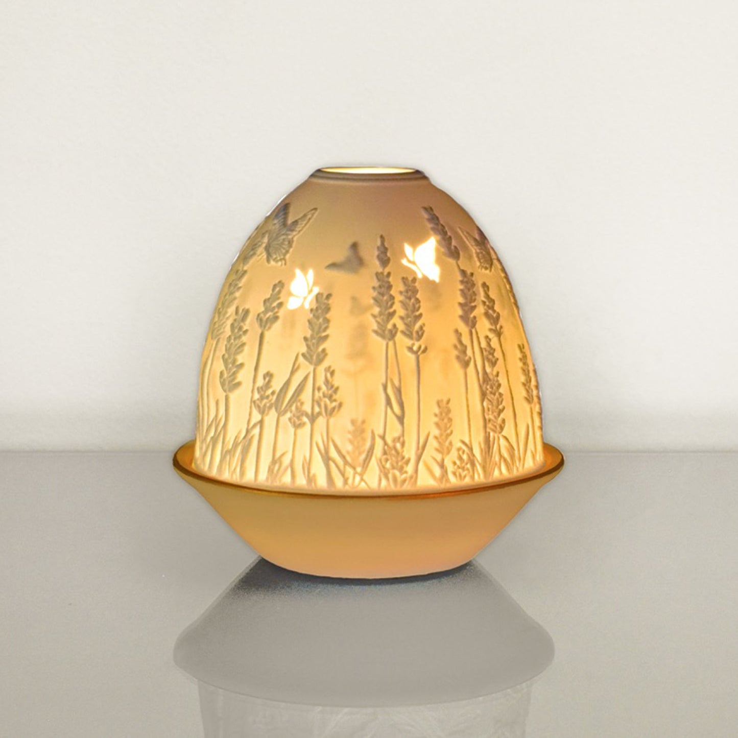 White porcelain tall dome candle holder with engraved lavender and gold rimmed plate lit up