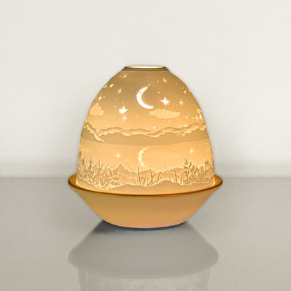 White porcelain tall dome candle holder with engraved starry night scene and gold rimmed plate - lit up