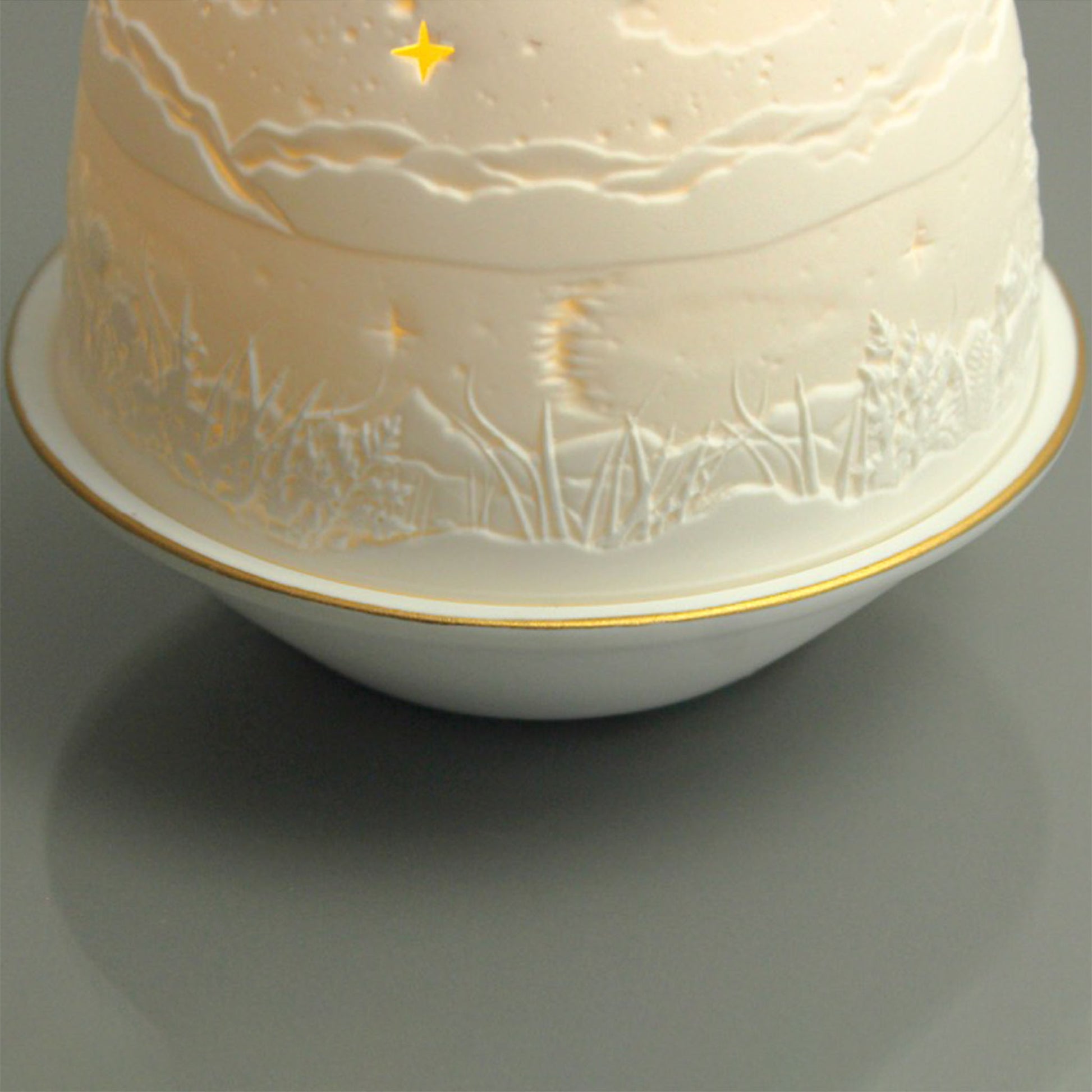 White porcelain tall dome candle holder with engraved starry night scene and gold rimmed plate detail 