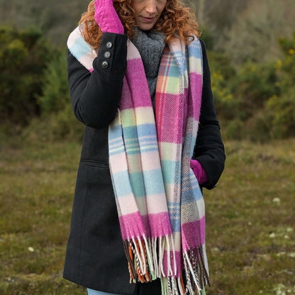 Model wearing a tartan check scarf in pastel colours and brown with tassel fringe